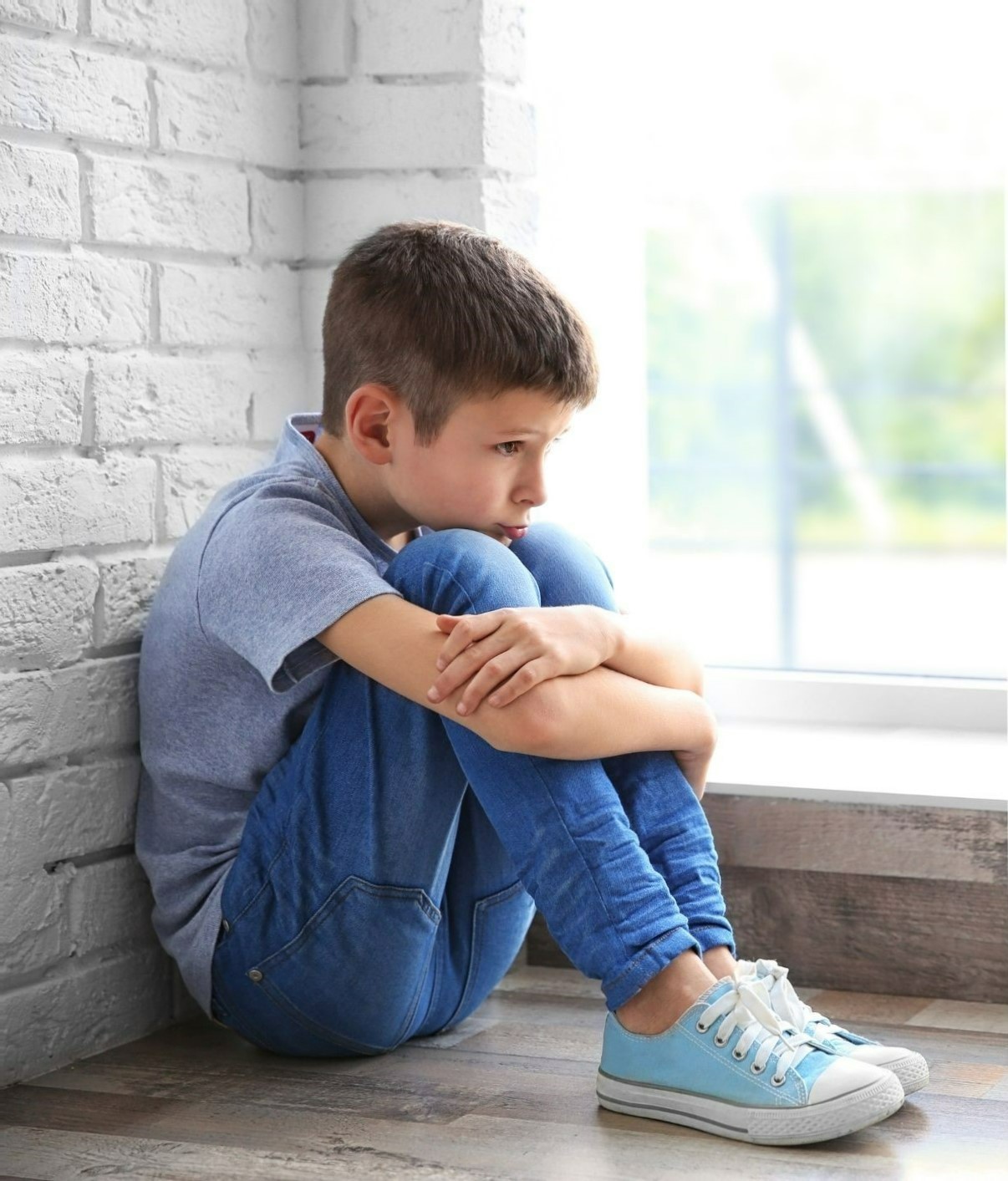 boy sitting with chin on knees